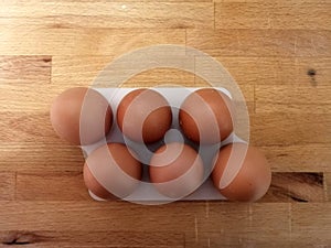 Brown Eggs in egg holder. Wood backgraund.