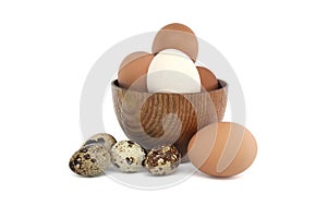 Brown eggs and smaller quail eggs isolated on white