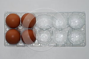 brown eggs in transparent plastic tray