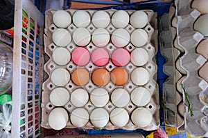 Brown eggs white eggs and pink eggs in black tray.