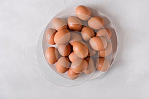 Brown eggs on a white plate on a white background. Eggs. Easter photo concept.