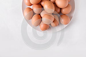 Brown eggs on a white plate on a white background. Eggs. Easter photo concept.