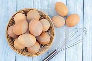 Brown eggs in a wooden weave basket on wooden floor