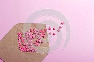 Brown envelope with purple hearts on pink paper or cardboard background.