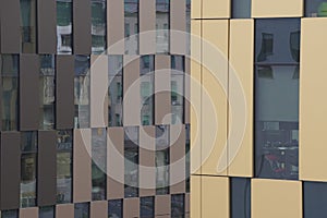 Brown facade of a modern building, office or residential building. red brick, lots of glass, skyscraper. Windows of different