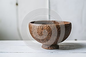 Brown fibrous cup with semi circular opening exudes rustic charm on white backdrop
