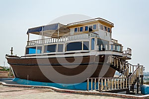 Brown fishing boat on the ground in chabahar