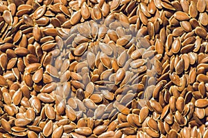 Brown flax seed background. Flax seed is a good source of omega-3 fatty acids, can aid in digestion, and is used to make linseed