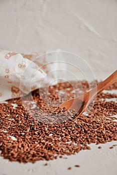 Brown flax seed background. Linseed grain wooden spoon texture. Flaxseed oil preparation.