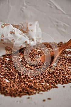 Brown flax seed background. Linseed grain wooden spoon texture. Flaxseed oil preparation.