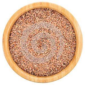 Brown flax seeds in wooden bowl isolated.