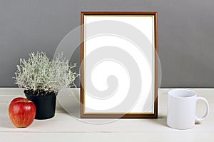 Brown frame mockup with plant pot, mug and apple on wooden shelf