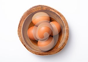 Brown fresh raw eggs in wooden bowl plate on white background