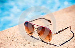 Brown funky sun glasses near swimming pool