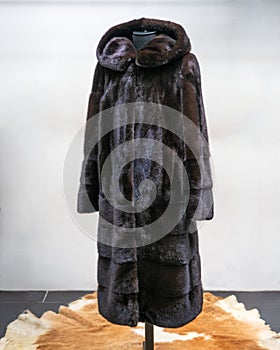 Brown fur coat made of mink fur, the hem is decorated with longitudinal strips of fur.