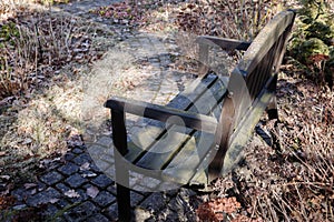 Brown garden bench, a cobbled track.