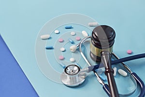 Brown gavel and a medical stethoscope on blue background. symbol photo for bungling and medical error