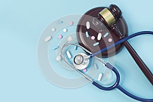 Brown gavel and a medical stethoscope on blue background. symbol photo for bungling and medical error.