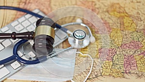 Brown gavel, medical stethoscope and mask on the map, the concept of the distribution of Covid 19 in the USA