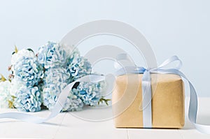 Brown gift box with blue ribbon bow and Hydrangea flowers