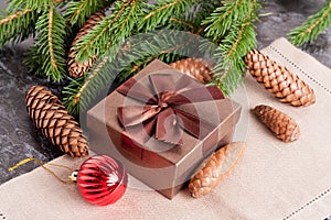 Brown gift box, Christmas bal, fir conesl and Green fir branches