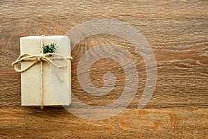 Brown gift box with festive decoration for Christmas and new year is on wood background. Top view with copy space, flat lay