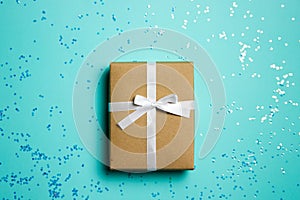 A brown gift box over the glitter mint background with copy space.