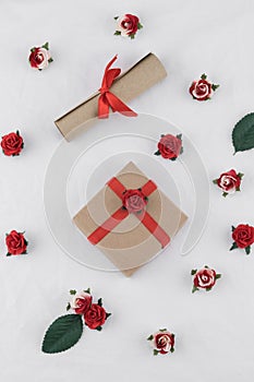 Brown gift box and scroll decorate with red rose paper flowers