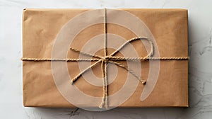 A brown gift wrapped with twine on a marble surface