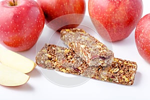Brown granola bars on red apples background