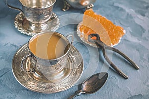 Brown Grape sugar in clear crystals, tea and tongs on grey slate close-up. Oriental sweetness to tea