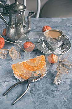 Brown Grape sugar in clear crystals, tea and tongs on grey slate close-up. Oriental sweetness to tea