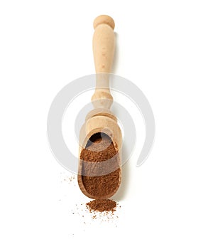 Brown ground cinnamon in a wooden spoon