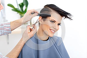 Brown Hair. Hairdresser Cutting Woman's Hair in Beauty Salon. Ha