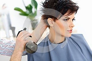 Brown Hair. The Hairdresser doing Hairstyle in Hair Salon.