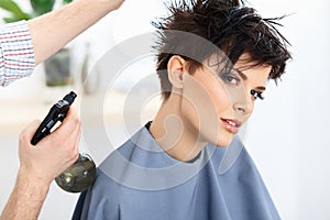 Brown Hair. The Hairdresser doing Hairstyle in Hair Salon.