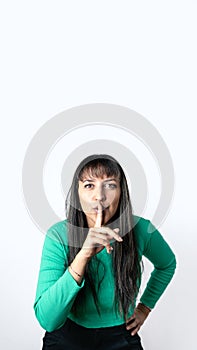 Brown hair woman with Hispanic features making silence gesture with her finger on lips over isolated white background