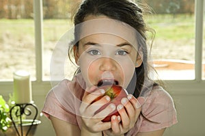 Brown haired child eating an apple