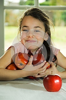 Brown haired child holding apples