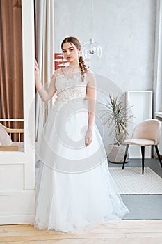 Brown-haired girl in a beautiful white wedding dress. A woman bride is waiting for the groom before the wedding