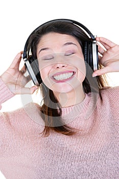 Brown haired girl with headphones listening to music with closed eyes on white background
