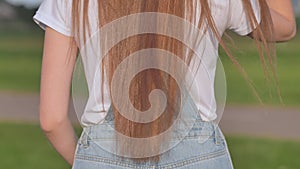 Brown-haired girl`s hair standing back.