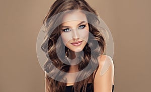 Brown haired woman with voluminous, shiny and curly hairstyle.Long hair and makeup.