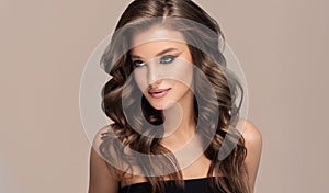 Brown haired woman with voluminous, shiny and curly hairstyle.Long hair and makeup.