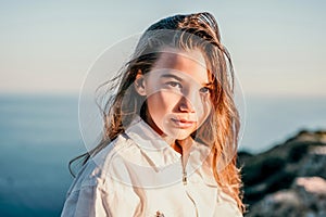 Adorable teenage girl outdoors enjoying sunset at beach on summer day. Close up portrait of smiling young romantic