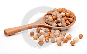 Brown hazelnuts on a wooden spoon isolated on white background