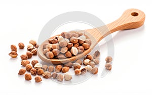 Brown hazelnuts on a wooden spoon isolated on white background. Close up view photo