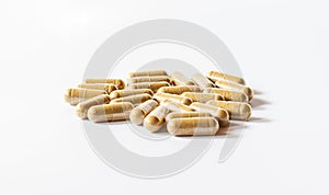 Brown herbal capsules on a white background