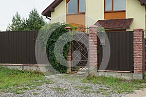 Brown iron door and a long metal fence