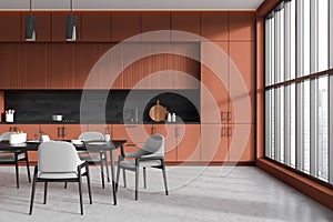 Brown kitchen interior with eating area near panoramic window